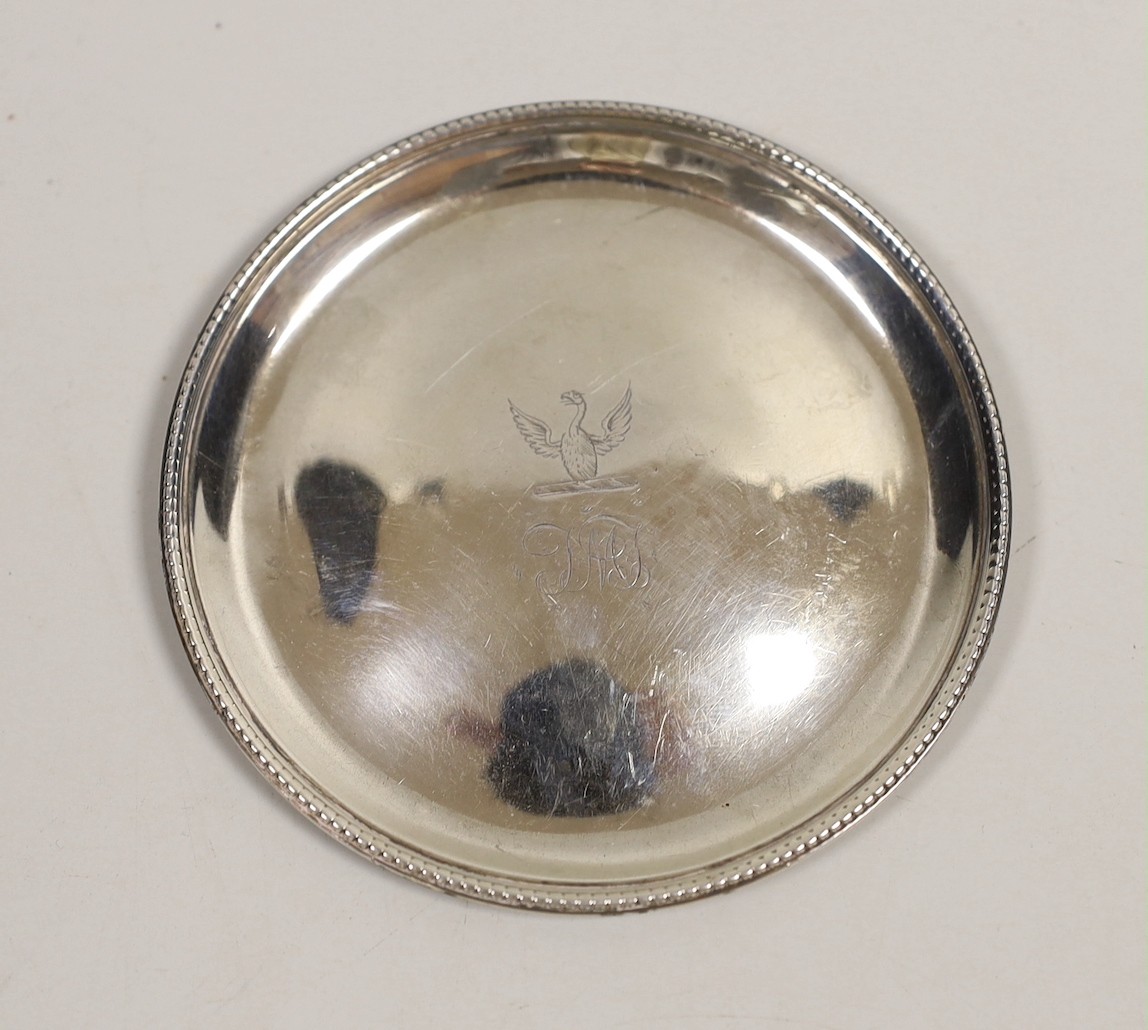 A George III silver glass coaster, William Plummer, London, 1781, 91mm, together with a pair of early 19th century Irish silver condiment spoons and a white metal cartouche.